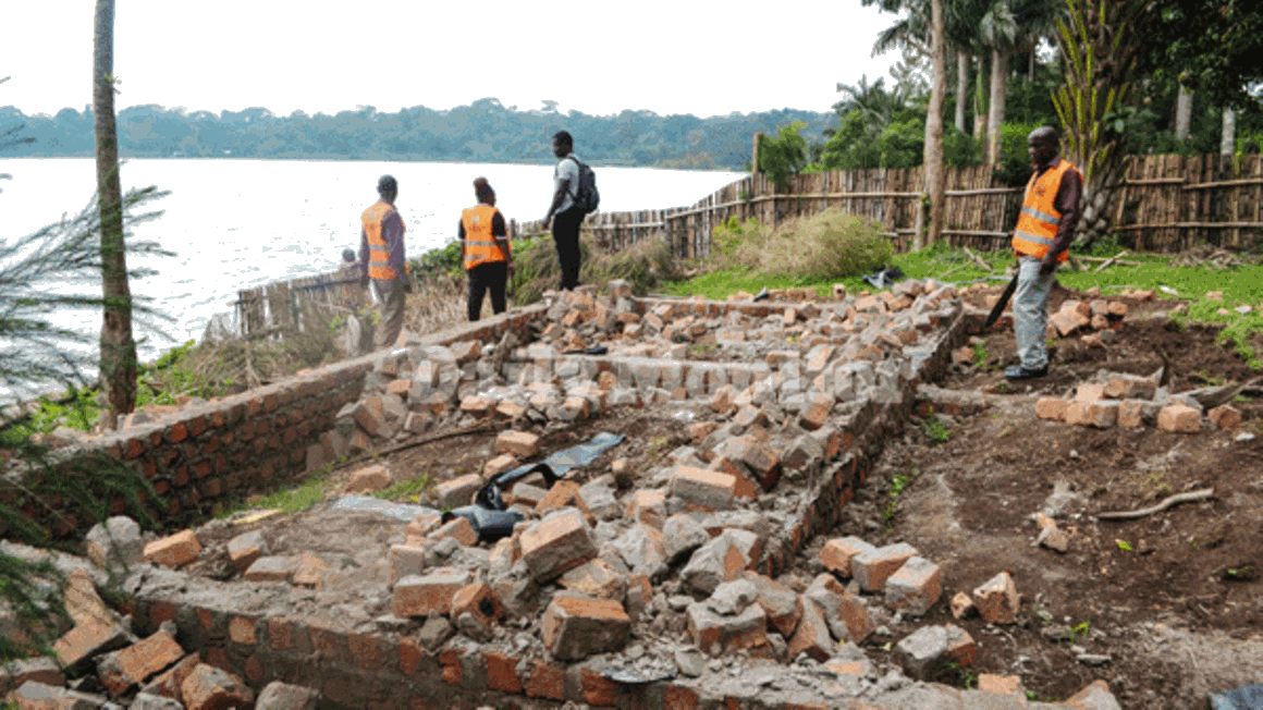 Entebbe Municipality law enforcement team demolishes structures in the buffer zones on Nambi Road in November 2019. However, some owners of the illegal structures have since reconstructed them. Officials are asking for a review of land titles along Lake Victoria.