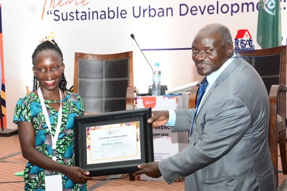 Works and Transport Minister Gen Katumba Wamala (right) hands over a certificate of appreciation to Ms Mary Adweo
