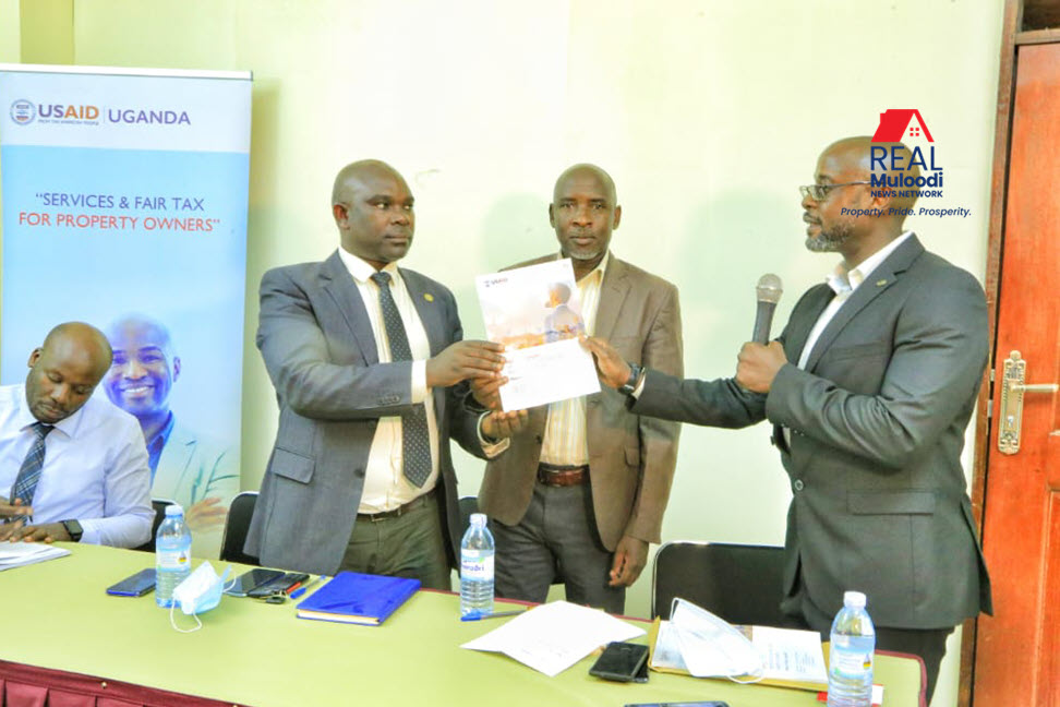 Hussein Sekinalya, Director of Client Relations at RippleNami Uganda, handing over the report to Mbarara City officials