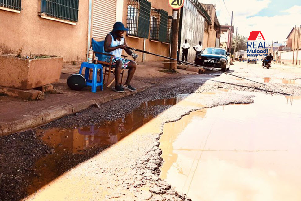Kampala Potholes - Fishing in the twin Lakes of 7th Street. #KampalaPotholeExhibition.